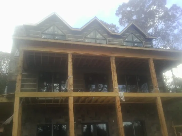 Dormers and porch framing on a large log home under construction — Roof Coating work by our crew in Union Hall