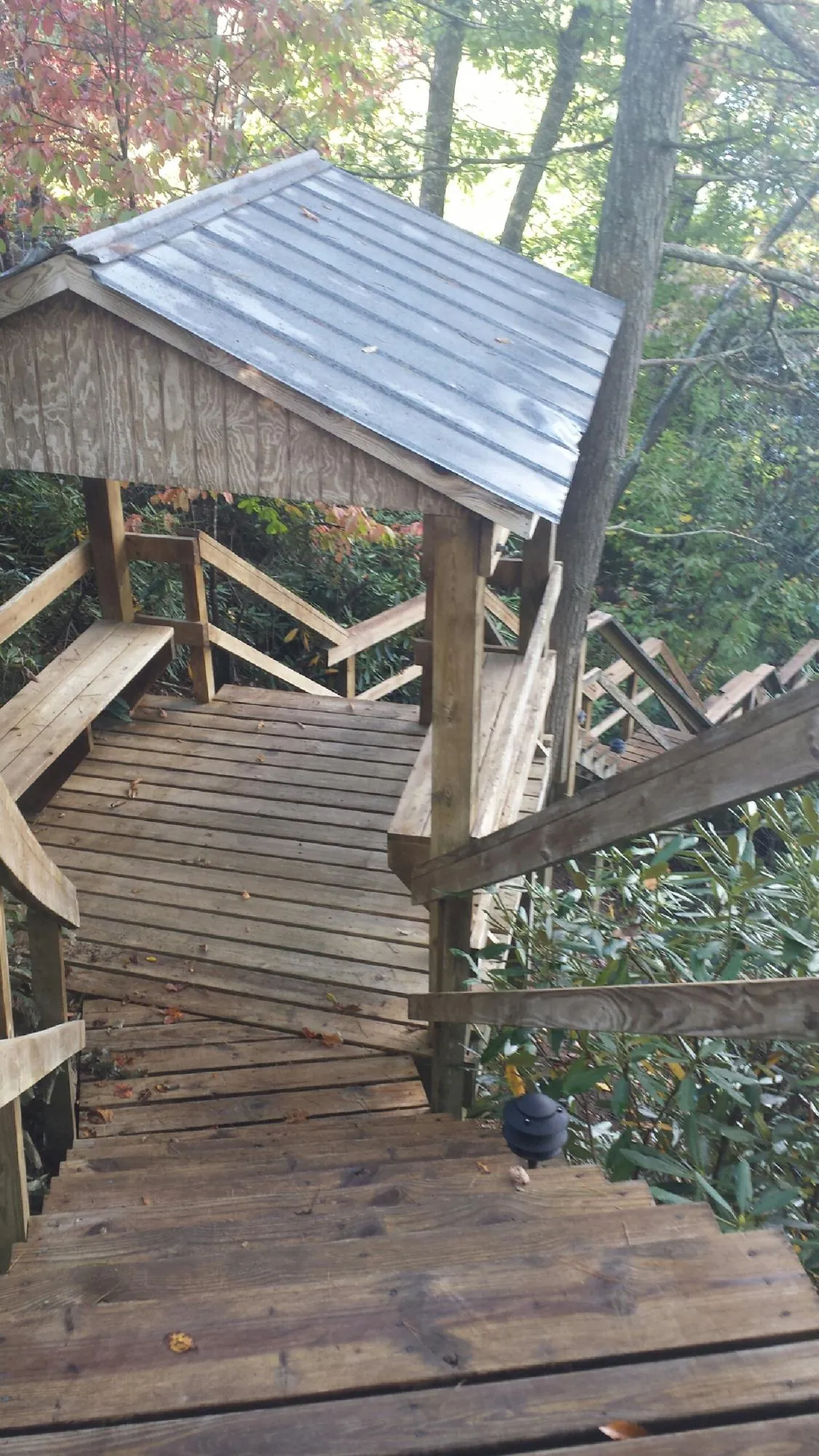 Metal roofed shelter over wooden steps on a wooded walkway — Skylight Repair & Installation work by our crew in Union Hall