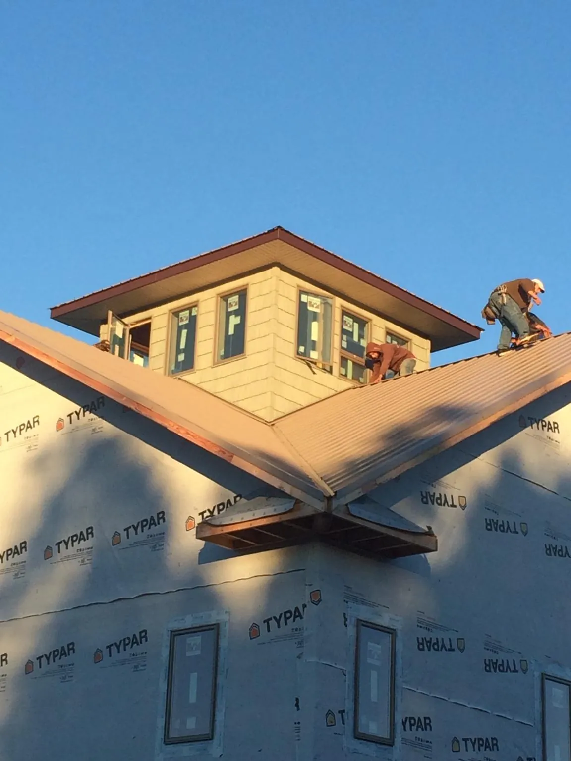 Roofers working around a rooftop cupola on a new metal roof at sunset — Roof Waterproofing in Union Hall by Roofing Brothers